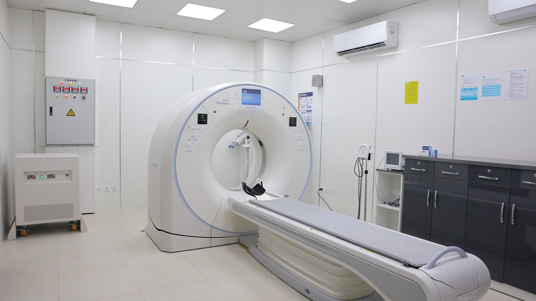 A CT scanner and its patient table in a clean, brightly lit scanning room.